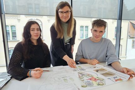 Baubürgermeisterin Silvia Queck schaut Emma Jenkner und Lennox Schiecke über die Schulter.