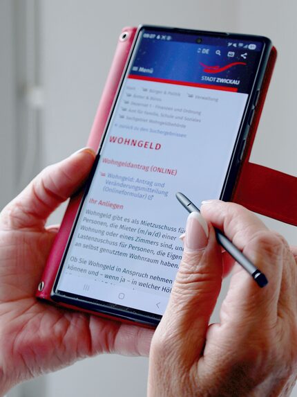 ein Handy zeigt die digitale Seite mit Antrag