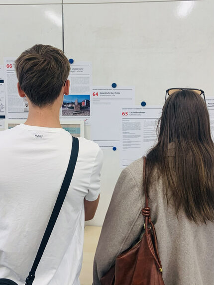 Besucher sehen sich die Präsentation der Vorschläge an