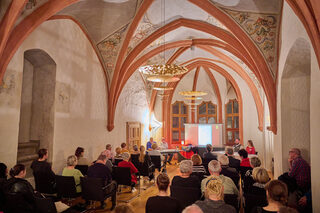 Besucher verfolgen eine Veranstaltung mit Vortrag in der Jakobskapelle im Zwickauer Rathaus.