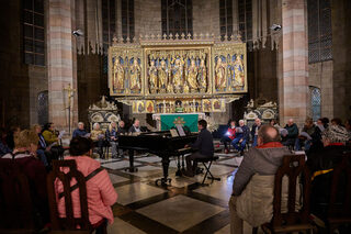 Ein Pianist musiziert vor einem Altar im Dom St. Marien.
