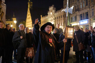 Ein kostümierter Nachtwächter führt eine Besuchergruppe bei Dunkelheit durch die Zwickauer Innenstadt.